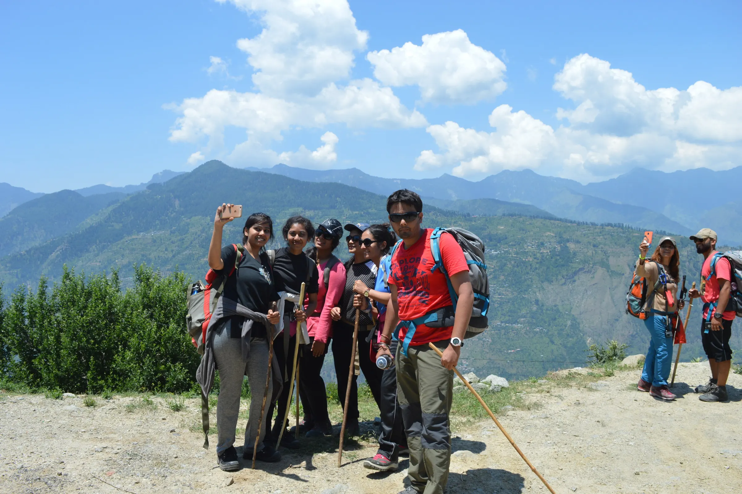 A trekking group at the trailhead, poles out and packs on